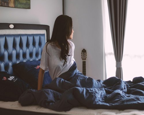 Person enjoying a calm morning with soft natural light entering through the window